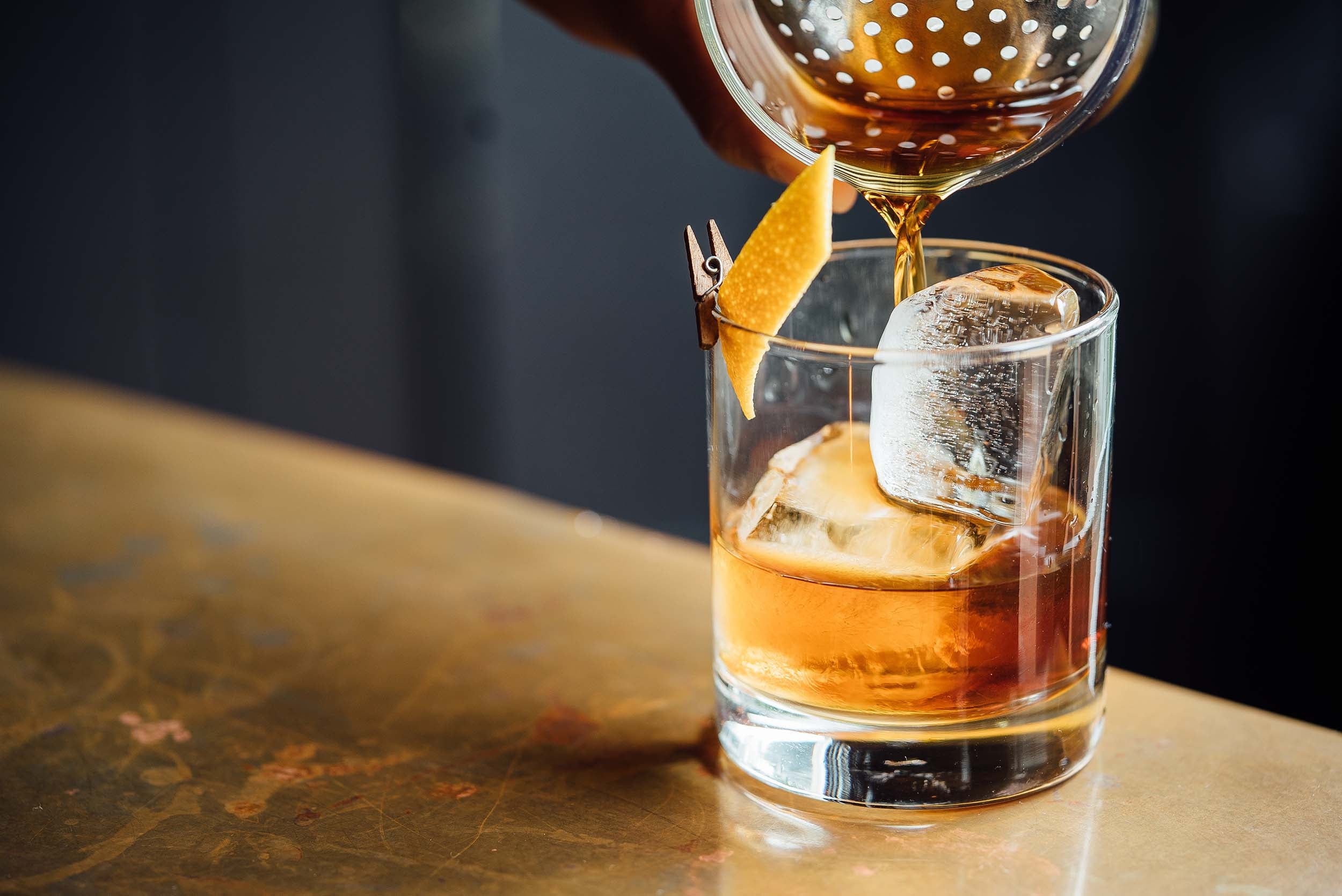 Close up pouring an old fashioned cocktail