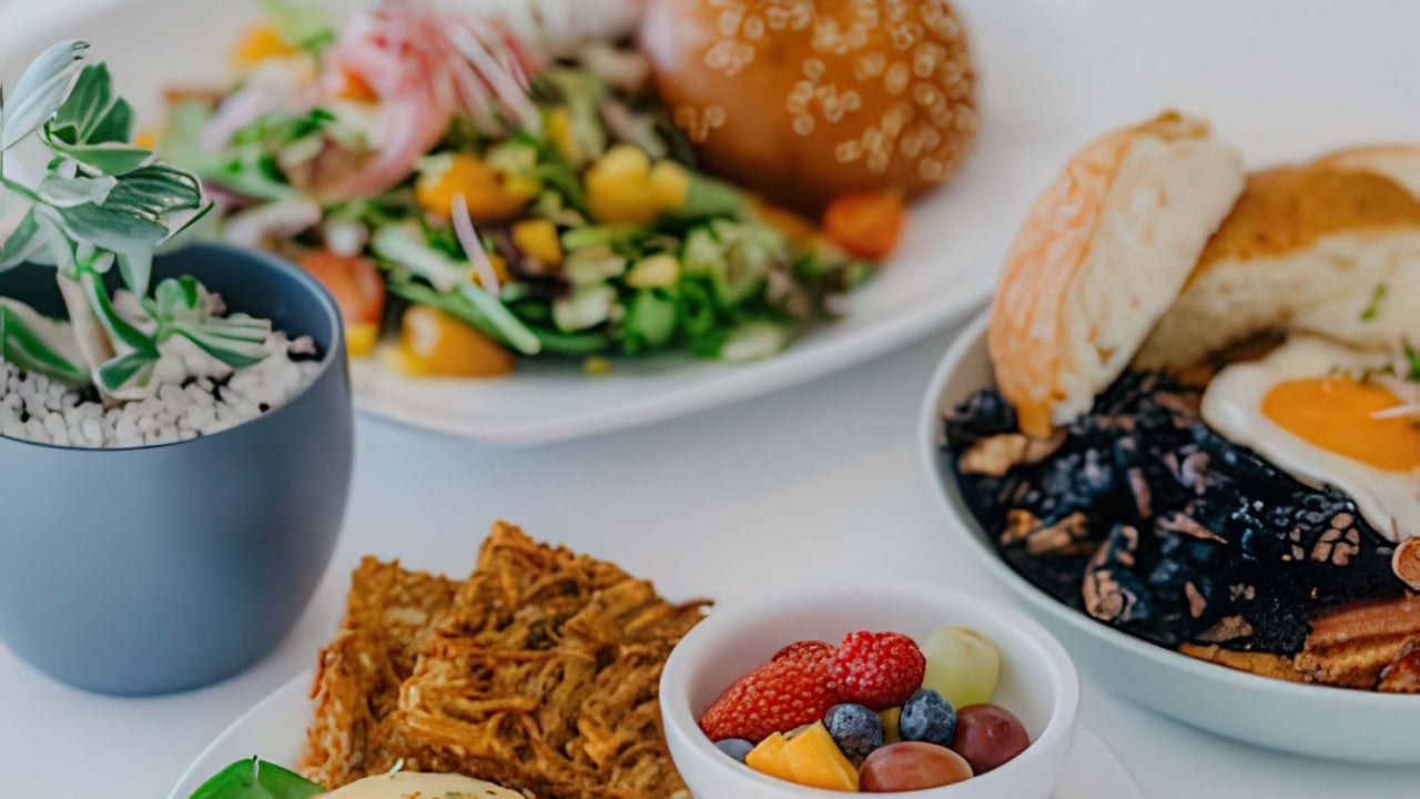 A variety of breakfast dishes sit on a white table cloth