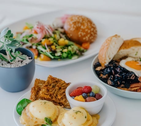A variety of breakfast dishes sit on a white table cloth