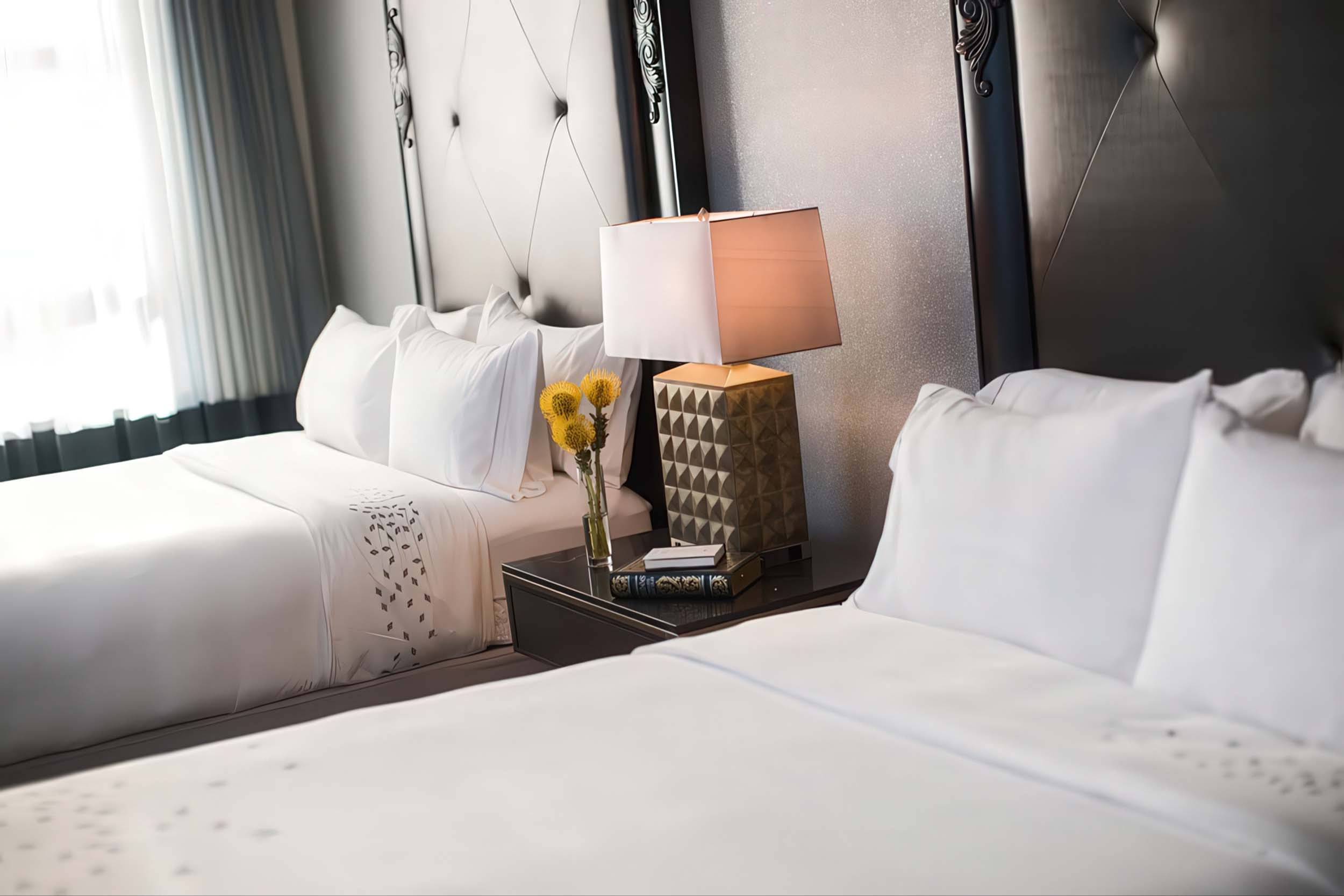 Two queen beds with a nightstand between them